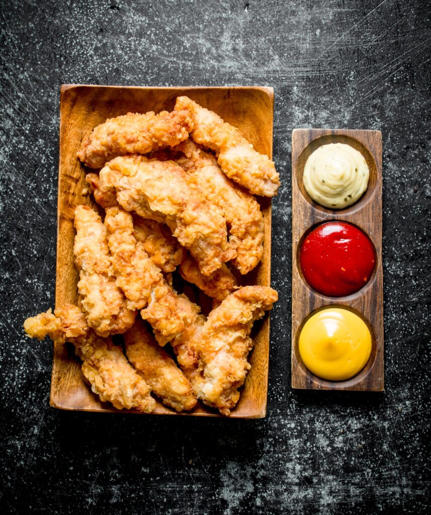 Chicken strips with different sauces.