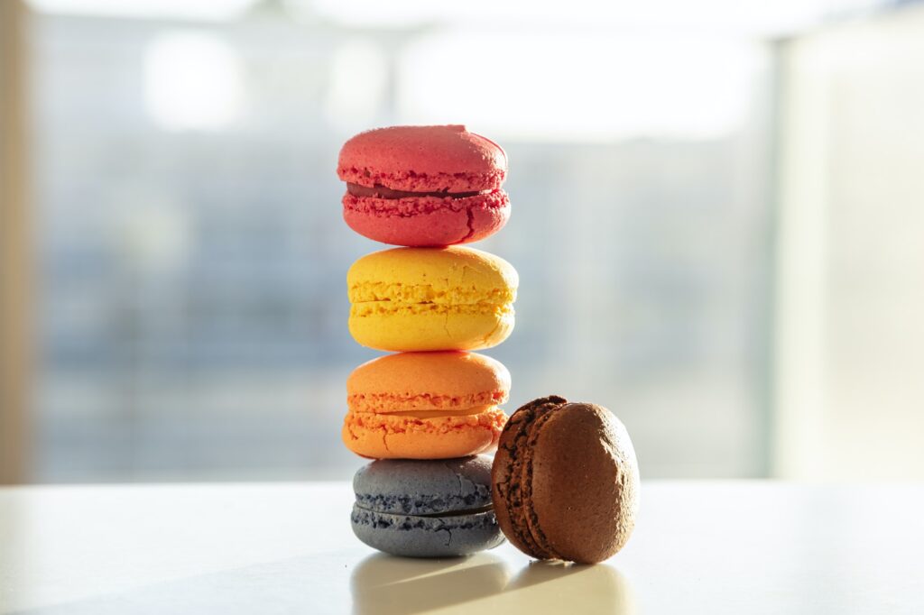 Colorful macarons pile on white background, close up view Colorful macarons pile on white background, close up view